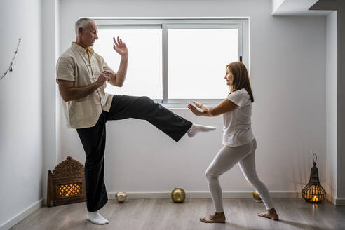 Mann und Frau üben Kampfsport im Fitnessstudio - DLTSF00502
