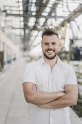 Portrait of smiling young man with arms crossed - KNSF07600