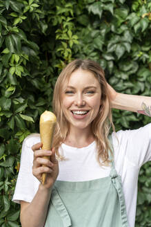 Porträt einer glücklichen jungen Frau mit Eiswaffel - AFVF05432