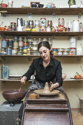 Woman working on workpiece in pottery - VPIF02012