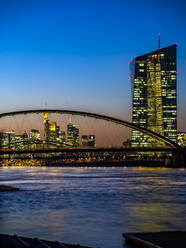 Deutschland, Hessen, Frankfurt, Skyline von Frankfurt am Main hinter der Ostendbrücke und der Europäischen Zentralbank in der Abenddämmerung - AMF07833