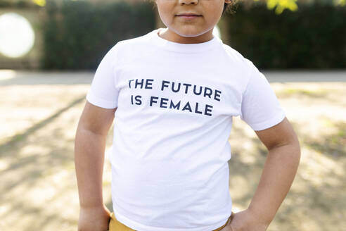 Stolzer kleiner Junge auf der Straße mit aufgedrucktem T-Shirt, auf dem steht, dass die Zukunft weiblich ist - VABF02648