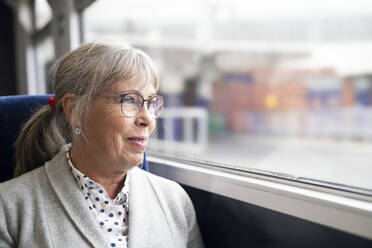 Frau im Bus schaut durch das Fenster - JOHF08006