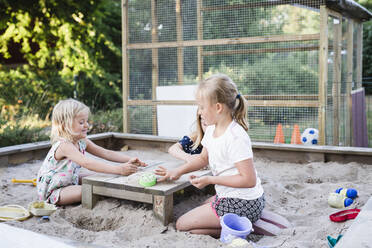 Mädchen spielen im Sandkasten - JOHF08033