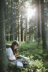 Frau liest im Wald - JOHF08131