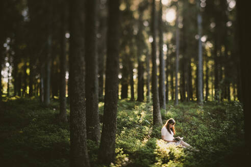 Frau sitzend im Wald - JOHF08132