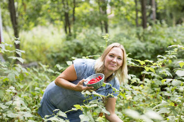 Woman picking raspberries - JOHF08190