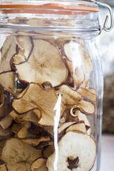 Close up of dried apple slices in a glass jar. - MINF13655