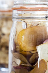 Close up of dried apple slices in a glass jar. - MINF13656