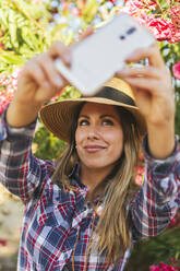 Junge Frau macht ein Selfie auf dem Land - CAVF74686