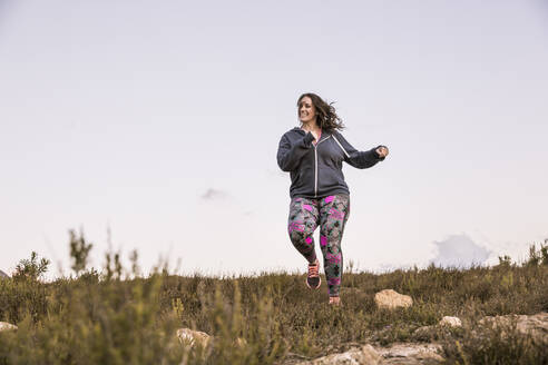 Plus-Size-Model jogging in the countryside at sunset - SDAHF00208