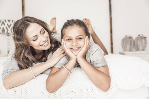 Porträt von Mutter und Tochter, die zusammen auf einem Bett liegen und sich entspannen - SDAHF00219