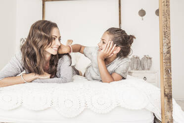 Mutter und Tochter liegen zusammen auf dem Bett und entspannen sich - SDAHF00220