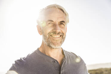 Portrait of smiling grey-haired man at sunset - SDAHF00258