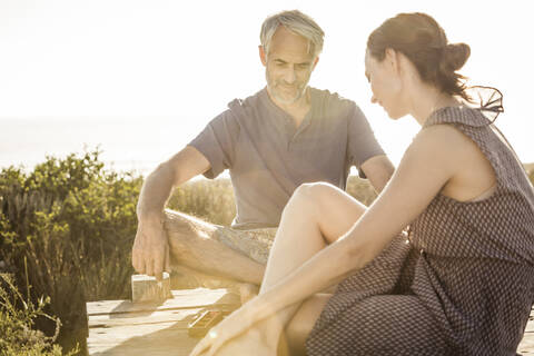 Paar sitzt an der Strandpromenade an der Küste und spielt Backgammon, lizenzfreies Stockfoto