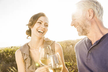 Happy couple having a glass of white wine at sunset - SDAHF00269