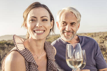 Glückliches Paar bei einem Glas Weißwein im Freien - SDAHF00271