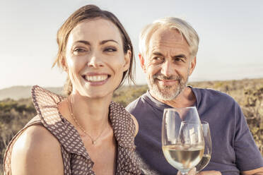 Happy couple having a glass of white wine outdoors - SDAHF00271