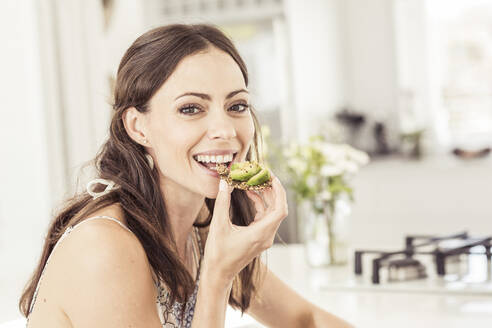 Porträt einer Frau, die ein gesundes Avocadobrot isst - SDAHF00325