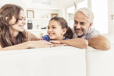 Happy family on couch in living room - SDAHF00334