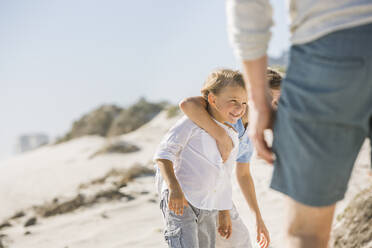 Vater hat Spaß mit seinen Söhnen am Strand, die zusammen spielen - SDAHF00375