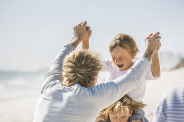 Vater hat Spaß mit seinen Söhnen am Strand, die zusammen spielen - SDAHF00376