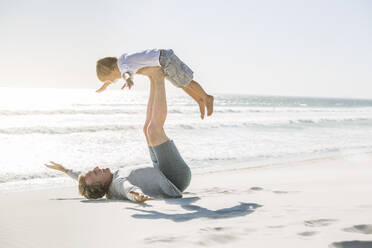 Vater hat Spaß mit seinem Sohn am Strand und tut so, als würde er fliegen - SDAHF00380