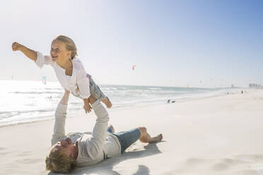 Vater hat Spaß mit seinem Sohn am Strand und tut so, als würde er fliegen - SDAHF00381