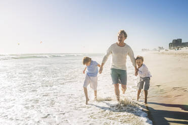 Vater geht mit seinen Söhnen am Strand spazieren - SDAHF00387