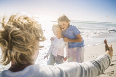 Father having fun with his sons on the beach - SDAHF00388