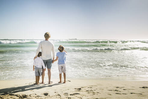 Father walking on the beach with his sons, watching the sea - SDAHF00390
