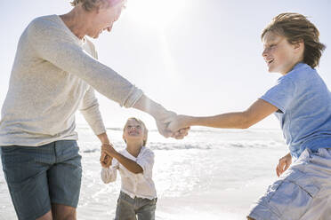 Father having fun with his son on the beach, holding hands - SDAHF00391