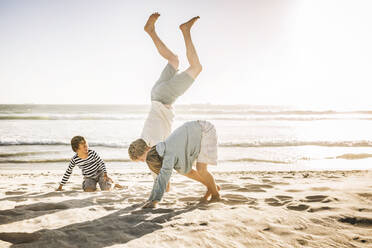 Father having fun with his son on the beach, practicing - SDAHF00399