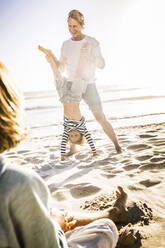 Vater hat Spaß mit seinem Sohn am Strand und übt Handstand - SDAHF00400