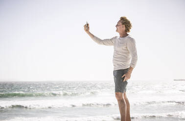 Mann, der ein Smartphone-Foto am Strand macht - SDAHF00413