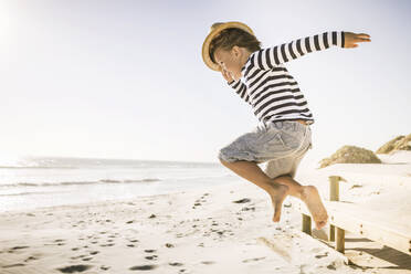 Junge mit Hut springt am Strand - SDAHF00414