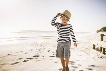 Portrait of smiling boy with hat on the beach - SDAHF00415