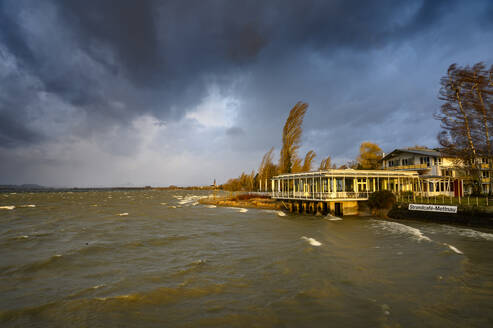 Germany, Baden-Wurttemberg, Radolfzell am Bodensee, Storm clouds over cafe on shore of Lake Constance - ELF02129