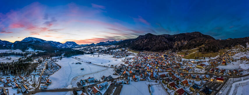 Deutschland, Bayern, Reit im Winkl, Blick aus dem Hubschrauber auf ein schneebedecktes Bergdorf in der Morgendämmerung - AMF07834