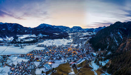 Deutschland, Bayern, Reit im Winkl, Blick aus dem Hubschrauber auf ein schneebedecktes Bergdorf in der Morgendämmerung - AMF07837