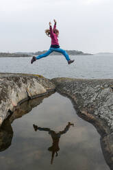 Girl jumping at lakeshore - JOHF08312