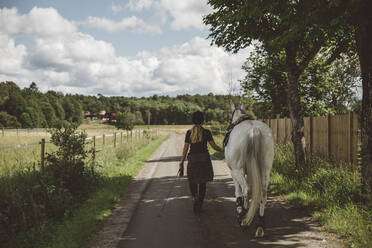 Frau mit Pferd auf der Straße - JOHF08327