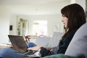 Young woman using laptop at home - JOHF08330