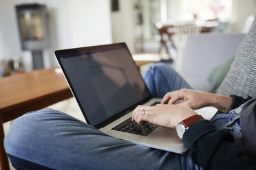 Junge Frau benutzt Laptop zu Hause - JOHF08331