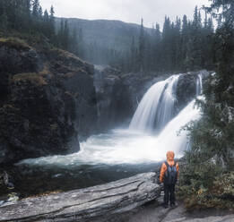 Hiker looking at waterfall - JOHF08367