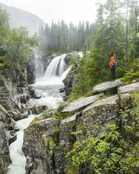 Hiker looking at waterfall - JOHF08368