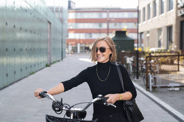 Lächelnde Frau mit Fahrrad - JOHF08393