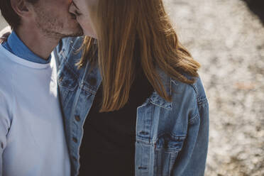 Couple kissing outdoors - JOHF08431