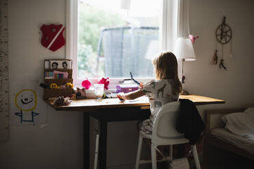 Girl sitting at desk - JOHF08643