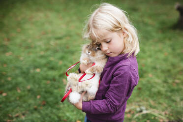 Mädchen umarmt Kaninchen - JOHF08660